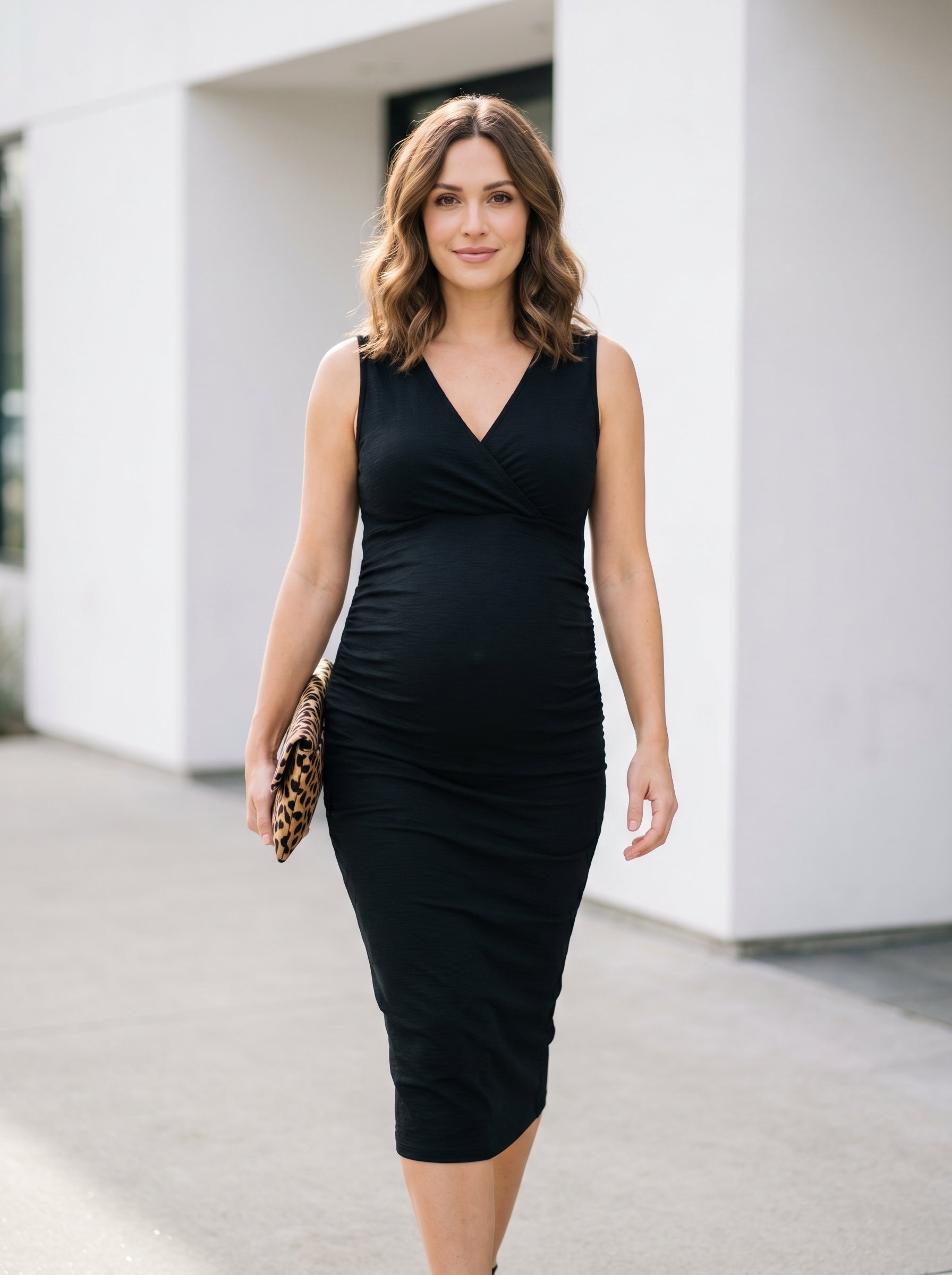 Pregnant woman wearing ChicDress™ sleeveless maternity dress in black, premium editorial